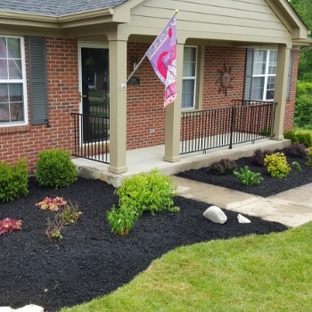 Mulch beds surrounding a home's front door. Pro Mow has cleaned the beds and put down fresh mulch. 
