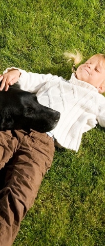 Girl with Dog Laying on Lawn